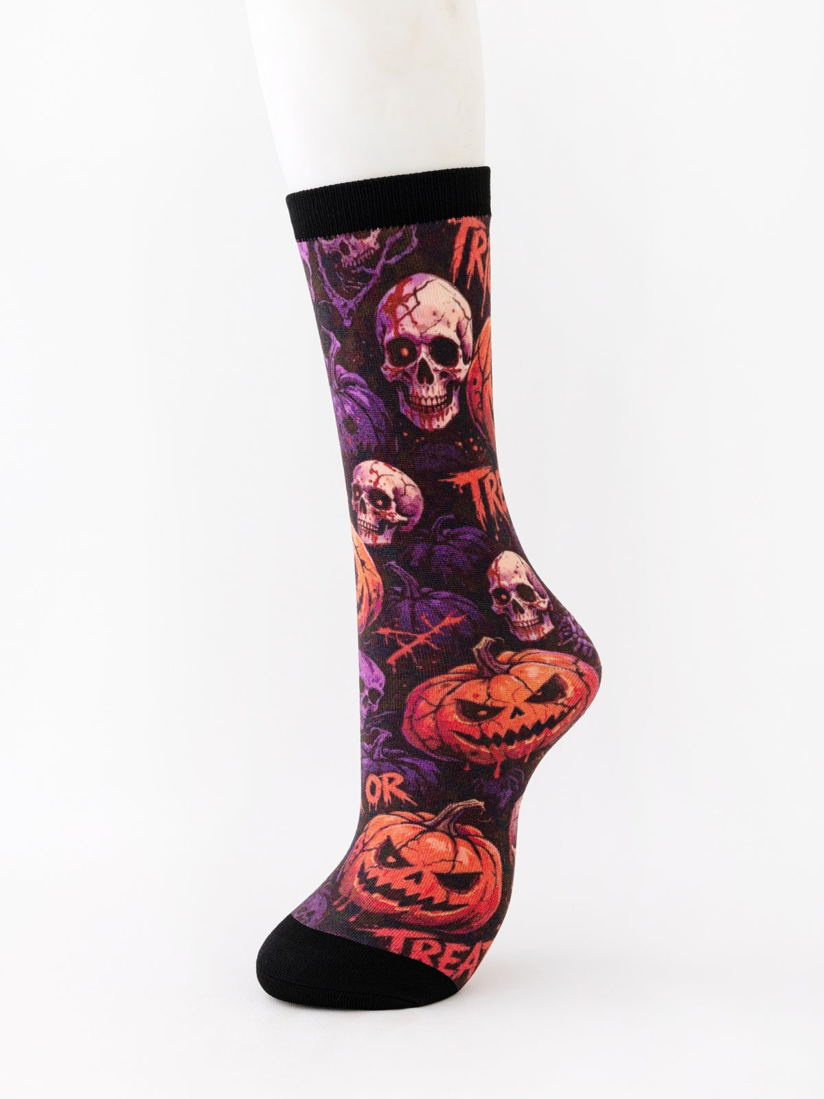 Mid-calf sock on a mannequin printed with skulls and grinning pumpkins on a purple ground