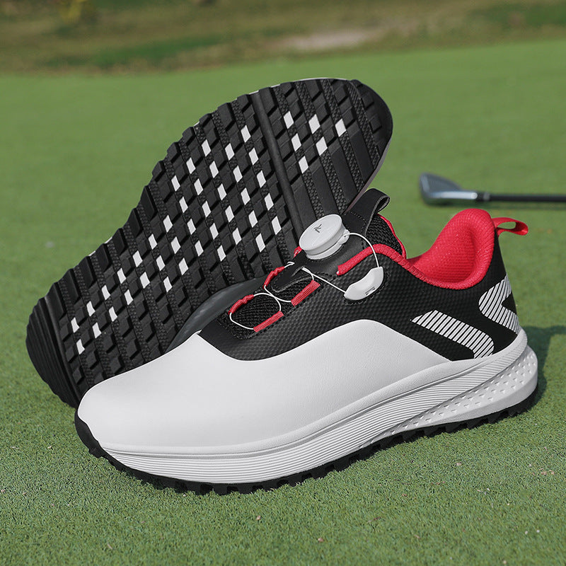 White and black golf shoe with red trim, a twist dial closure and a nubbed spikeless outsole
