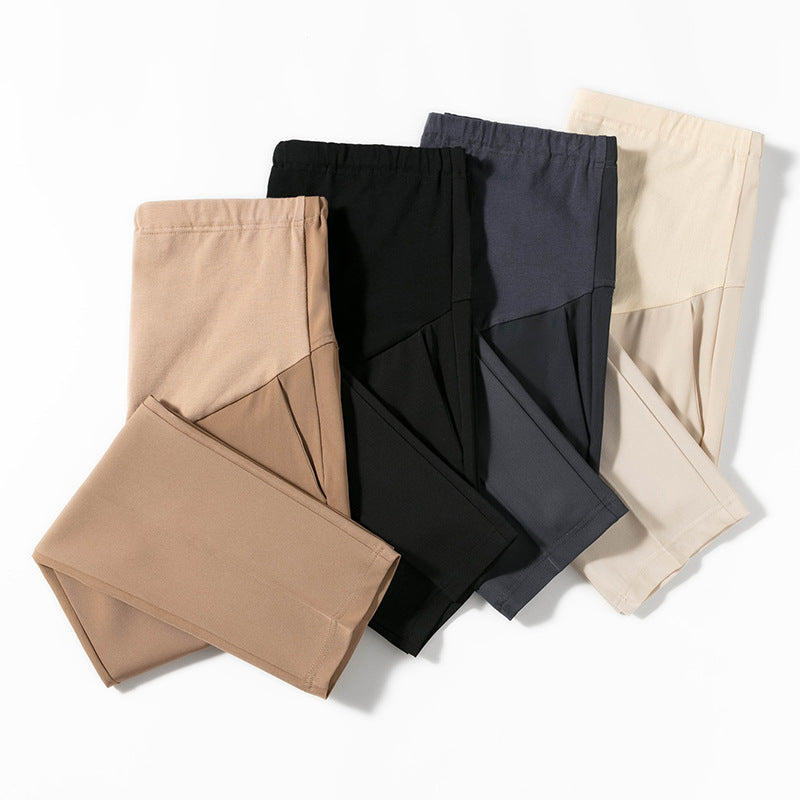 Folded maternity cropped trousers stacked to show the smooth poly cotton fabric and colours