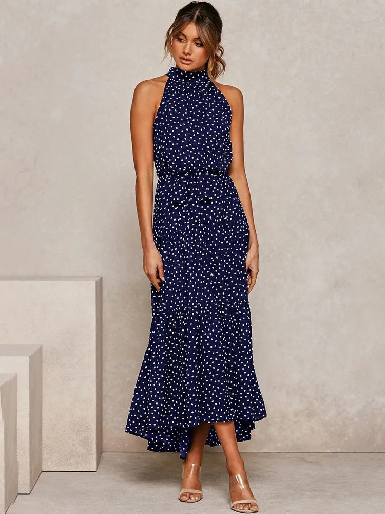 Navy polka dot halter neck sleeveless tiered swing maxi dress worn by a model