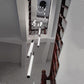 View from above of white LED tube lights hanging at different heights down a stairwell