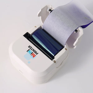 Open white mini printer showing the blue thermal transfer ribbon cartridge above the print head