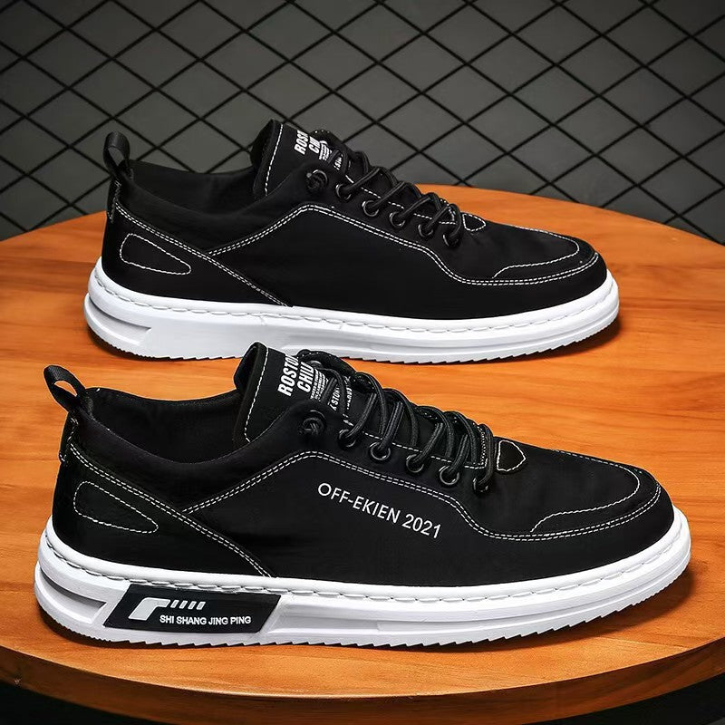 Black canvas low-top lace-up sneakers with white sole on a wooden table, size 43 option photo