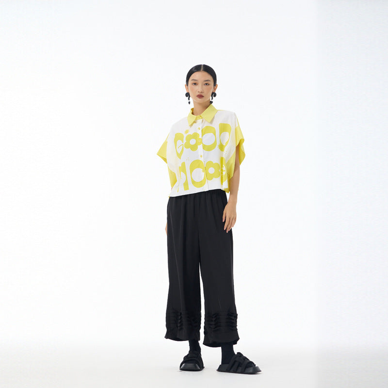 Full length view of yellow Good Mood cropped shirt with black wide leg trousers