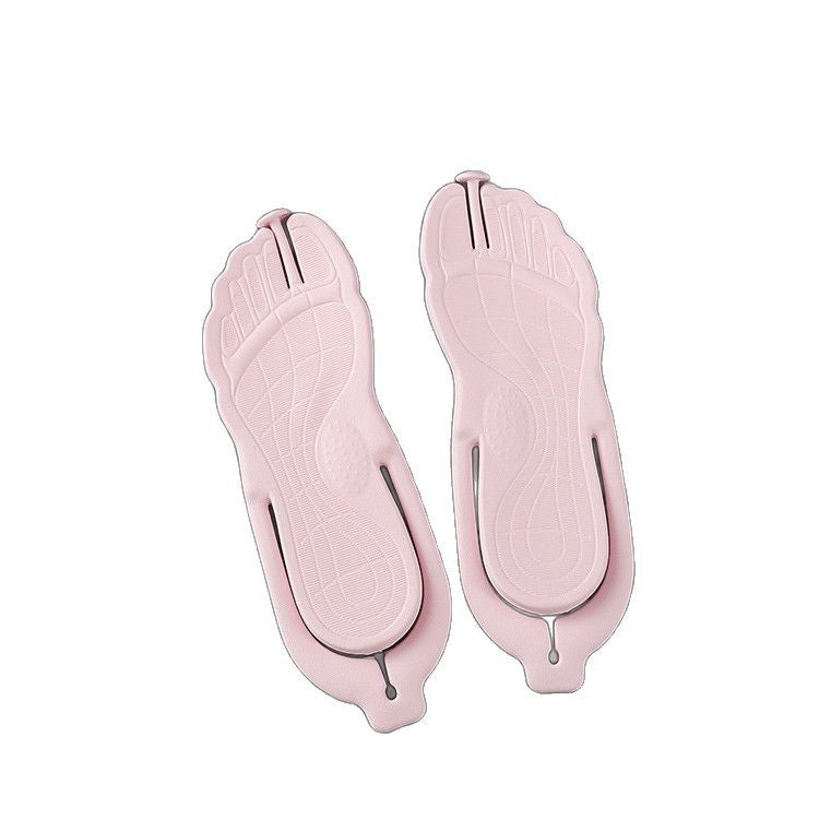 Pink folding flip flops seen from the sole showing foot-shaped tread and toe imprints