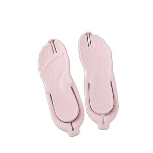 Pink folding flip flops seen from the sole showing foot-shaped tread and toe imprints