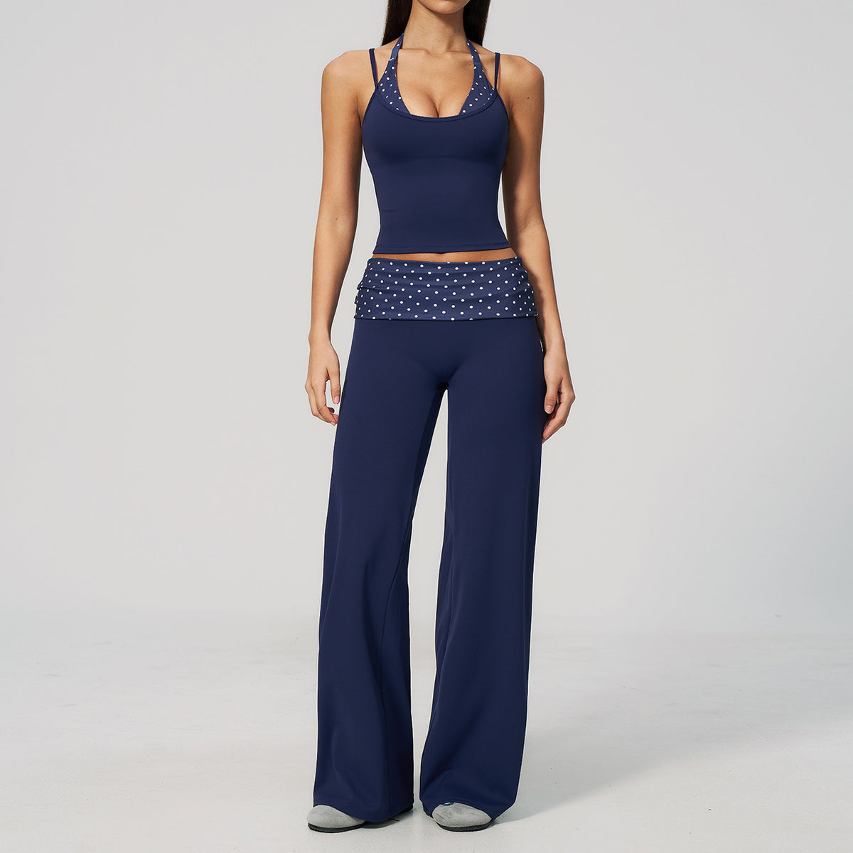 Model in a cropped camisole and wide leg fold over waist pants set, navy with white polka dots