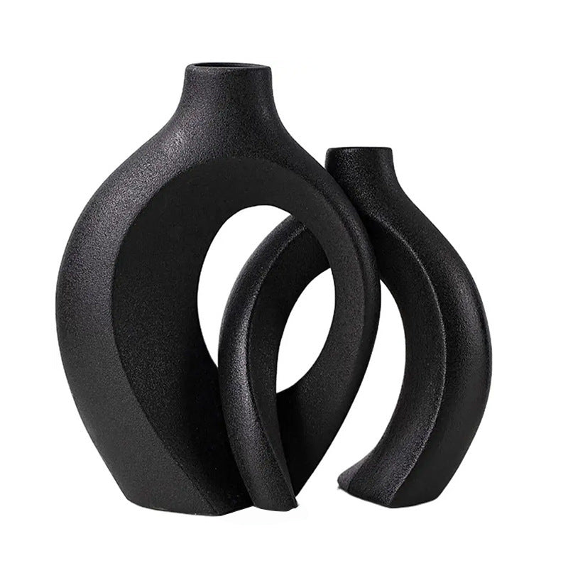 Two ceramic vases nested together with a small dried arrangement