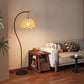 Arc lotus leaf floor lamp glowing warm beside a sofa in a living room corner