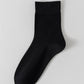 Black bamboo viscose blend mid calf sock laid flat on a pale background