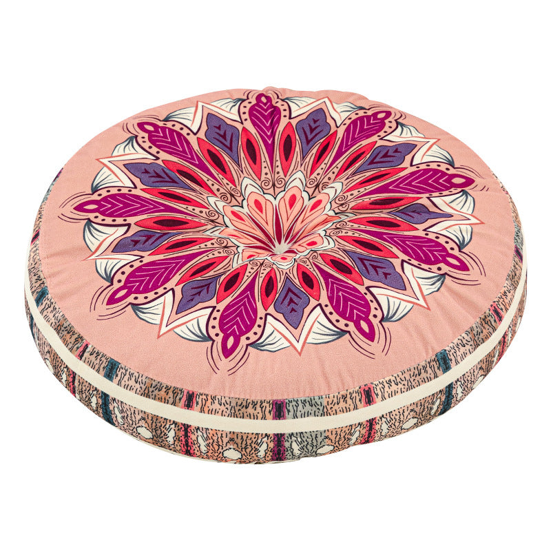 Round cushion with a magenta pink mandala print top and a pink striped side on a white background
