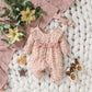 Side profile of baby floral romper showing the soft fabric drape