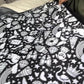 Kids coloring blanket held open showing black and white outline scene of animals and flowers