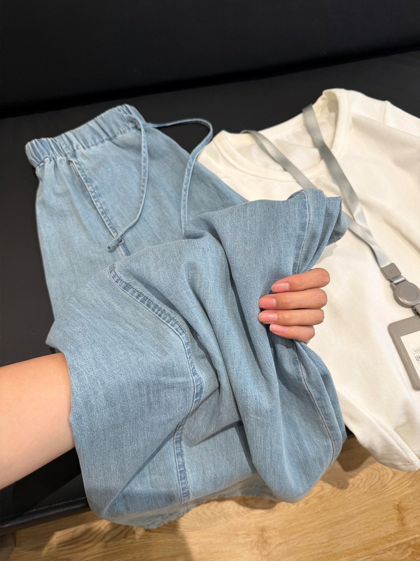 Light blue wide leg jeans folded beside a white tee showing the soft washed denim