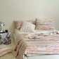 Pink marbled stripe plush throw blanket draped across a bed in a room