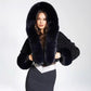 White vegan faux fur hooded cropped jacket full look worn with light trousers outdoors