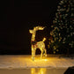 Small golden lit reindeer glowing on a white rug beside a Christmas tree in a dark room, 70 cm 3D style variant