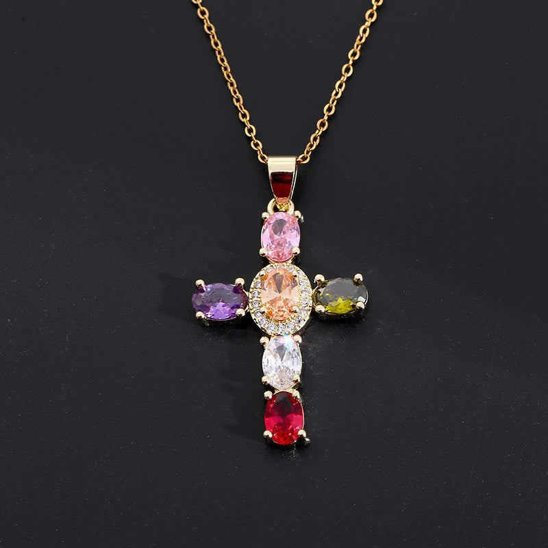 Gold tone cubic zirconia cross pendant with a shaped bail and lobster style clasp