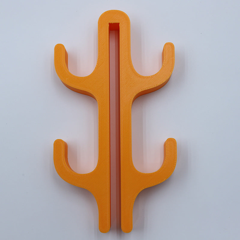 Orange resin four hook with four arms, seen from the front on a light background