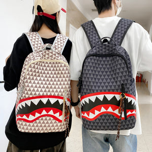 Man and woman wearing shark mouth print backpacks in cream and grey with hanging side charms