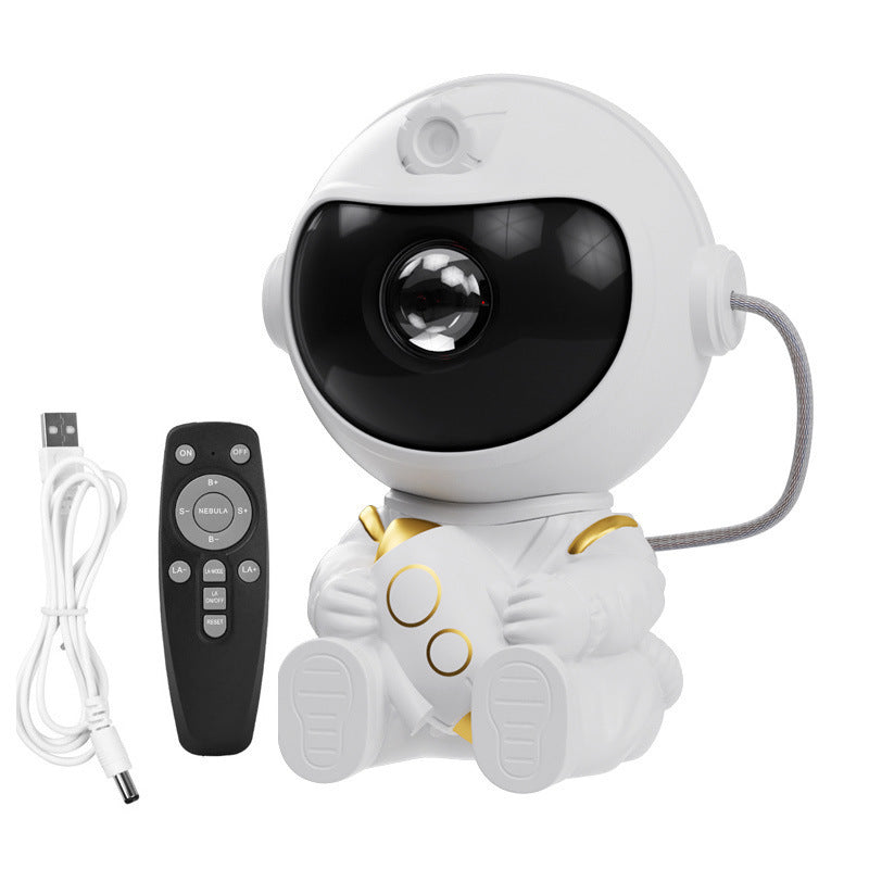 White astronaut projector shown with its remote control and braided USB charging cable