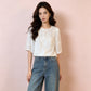 Ivory floral embroidered shirt half tucked into wide leg denim front view