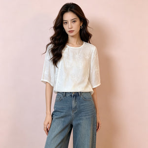 Ivory floral embroidered shirt half tucked into wide leg denim front view