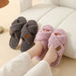 Woman wearing Light purple plush crossed strap slippers beside a pair of Grey slippers on a cream sofa