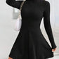 Black ribbed knit mock neck long sleeve fit and flare mini dress worn with a white chain shoulder bag