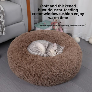 Ginger cat curled nose to tail inside the warm plush donut pet bed