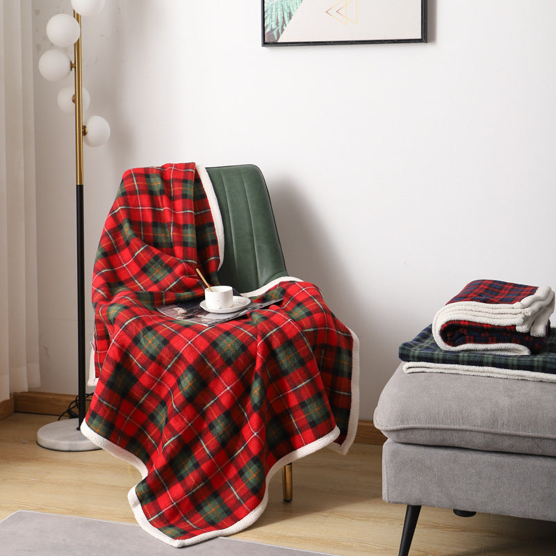 Red and green plaid coral fleece blanket in 140 x 200 cm draped over a chair with a cup