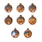 Clear Christmas ornament that catches the tree lights around a printed festive scene