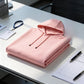 Pink pullover hoodie folded on a white desk with a badge lanyard and pen, a color not among the options