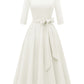 Full pleated swing dress with three quarter sleeves displayed on a plain backdrop