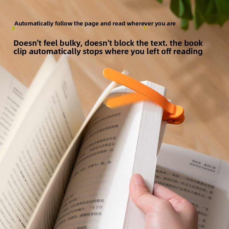 Orange silicone bookmark clip gripping an open book with its flexible arm resting across the current page