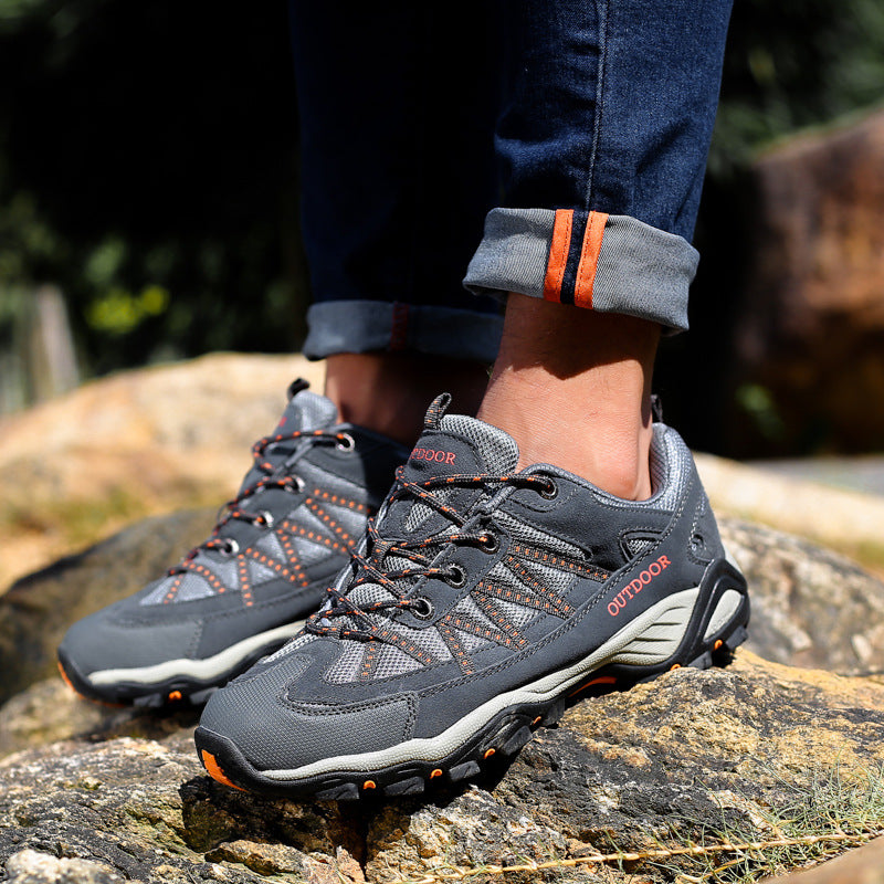 Close look at the deep lugged rubber outsole of a suede and mesh trail shoe