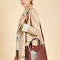Woman carrying the chestnut brown leather bucket tote on the shoulder, side view