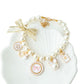 White faux pearl pet necklace collar with bow cameo and perfume bottle charm on a shell tray