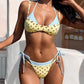 Pink polka dot triangle bikini worn by a pool, adjustable straps and tie side bottoms with hip bows