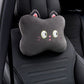Black cat headrest pillow with wide eyes and whiskers shown alone on a black car seat