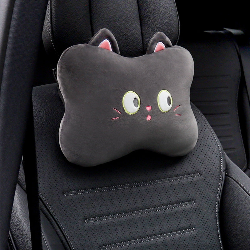 Black cat headrest pillow with wide eyes and whiskers shown alone on a black car seat