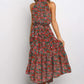Green and red boho floral halter neck sleeveless tiered swing maxi dress worn by a model