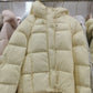 Down puffer jacket displayed flat, boxy loose cut with long rounded sleeves