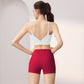 Back view of a woman in a white V-back sports bra and raspberry red high-waist shorts set, size L option
