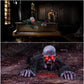 Crawling zombie prop shown draped over an old piano and crawling across dark ground with red eyes