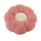Flower shaped plush cushion held up to show its rounded knit petals and soft loft