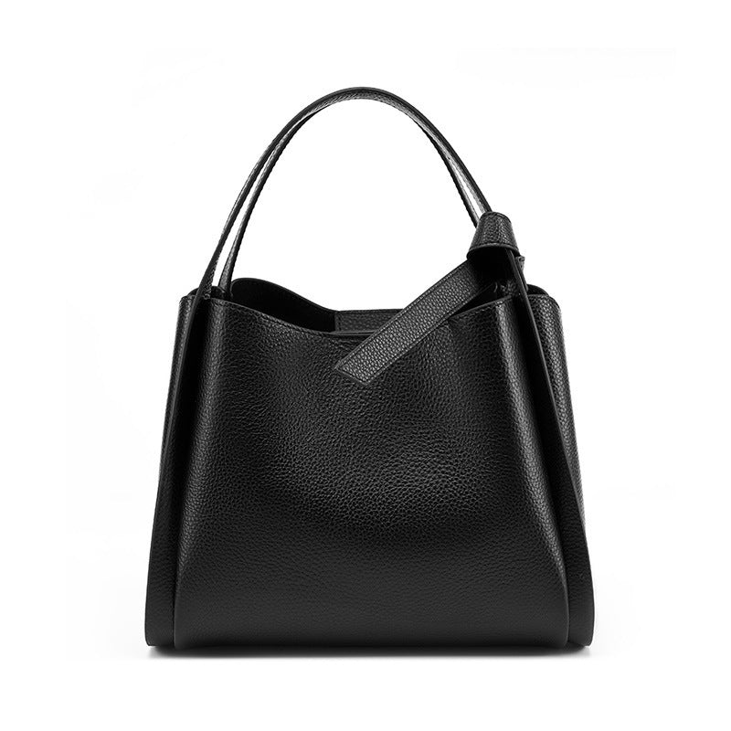 Black cowhide bucket bag front view with rolled handle and center notch