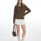 Full length view of the coffee brown toggle cardigan with a white pleated skirt, leg warmers and brown lace up shoes