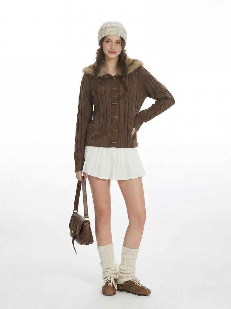 Full length view of the coffee brown toggle cardigan with a white pleated skirt, leg warmers and brown lace up shoes