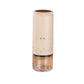 Cream electric coffee grinder with a brown display disc on top and an amber tinted clear cup on a white background